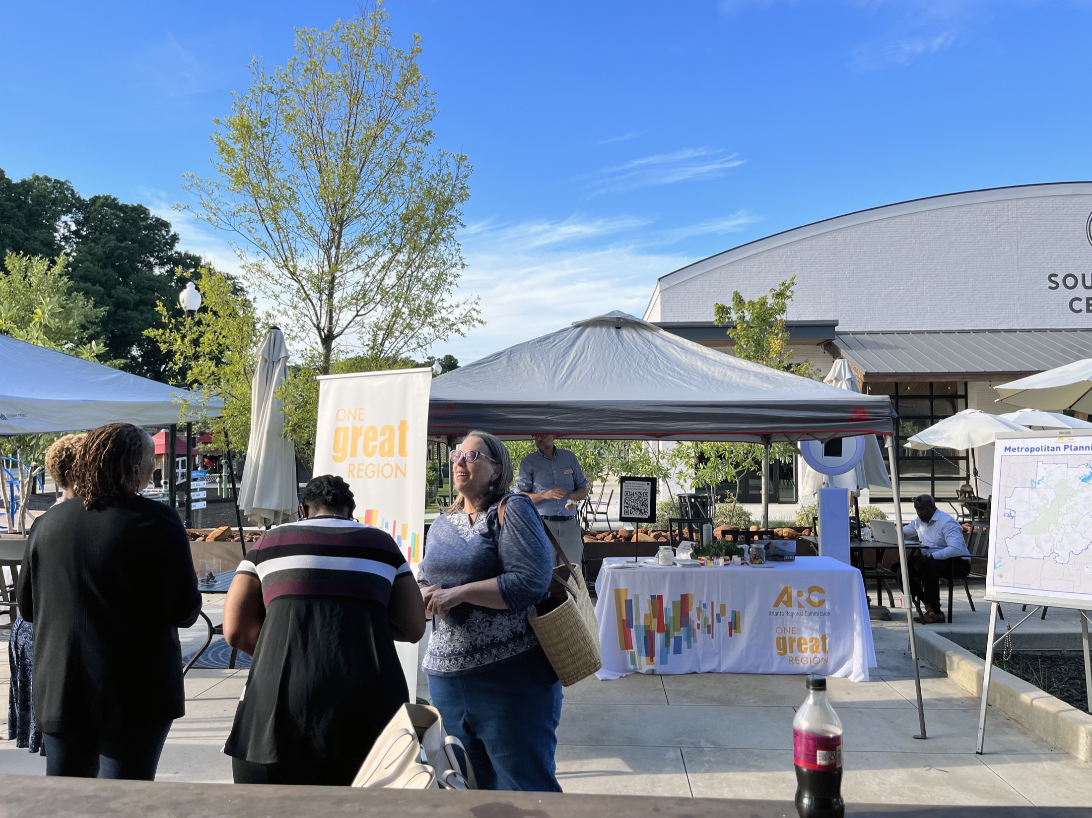 Community members speak with Atlanta Regional Commission staff at an outdoor outreach booth in Fayetteville.